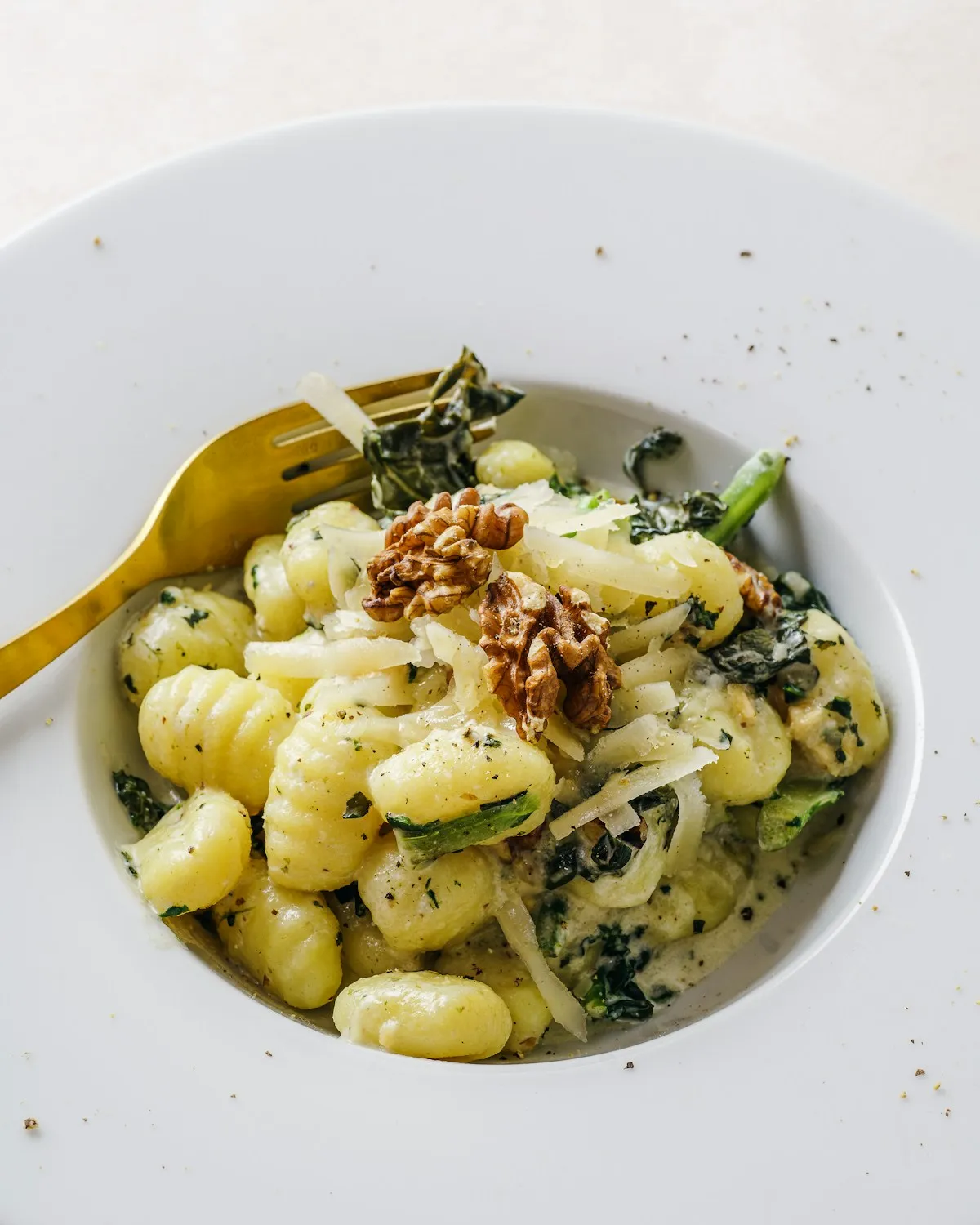 Pasta with kale and walnuts in a white bowl
